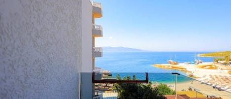Un balcón con vistas a una playa y al mar.