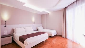 A modern hotel room with a large bed, a smaller bed, and a nightstand.