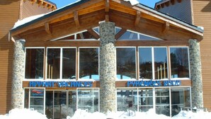 A hotel with a stone facade and large windows. - Wifi, 100m from resort center, fitness, swimming pool, terrace, balcony, tv, ski locker, 41m² (Pyrénées 2000)