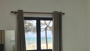 A hotel room with a bed, a desk with a chair, a TV, and a window with curtains. - Hotel Andi (Rrashbull)