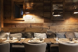Enjoy meals in this charming dining area with a long bench seating arrangement and pendant lights.