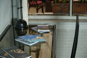 A glass partition with brochures and a black object, possibly a kettle, in a hotel setting. - B&B Cappotto Civico 48 (Pompei)