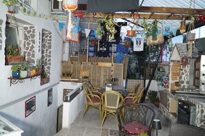 A patio area with wicker furniture, potted plants, and a stone wall. - B&B Cappotto Civico 48 (Pompei)