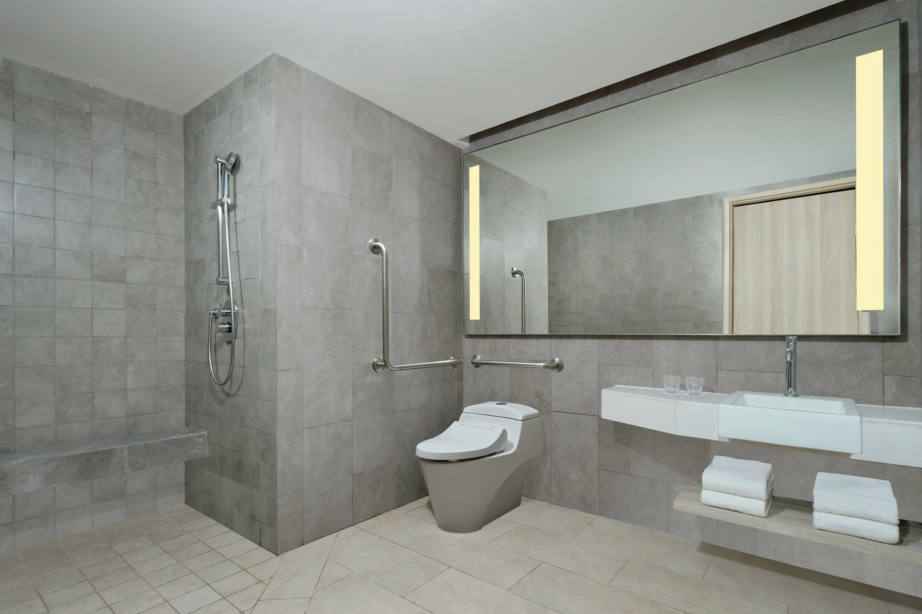 Une salle de bain moderne équipée de toilettes, d’un lavabo et d’une douche.
