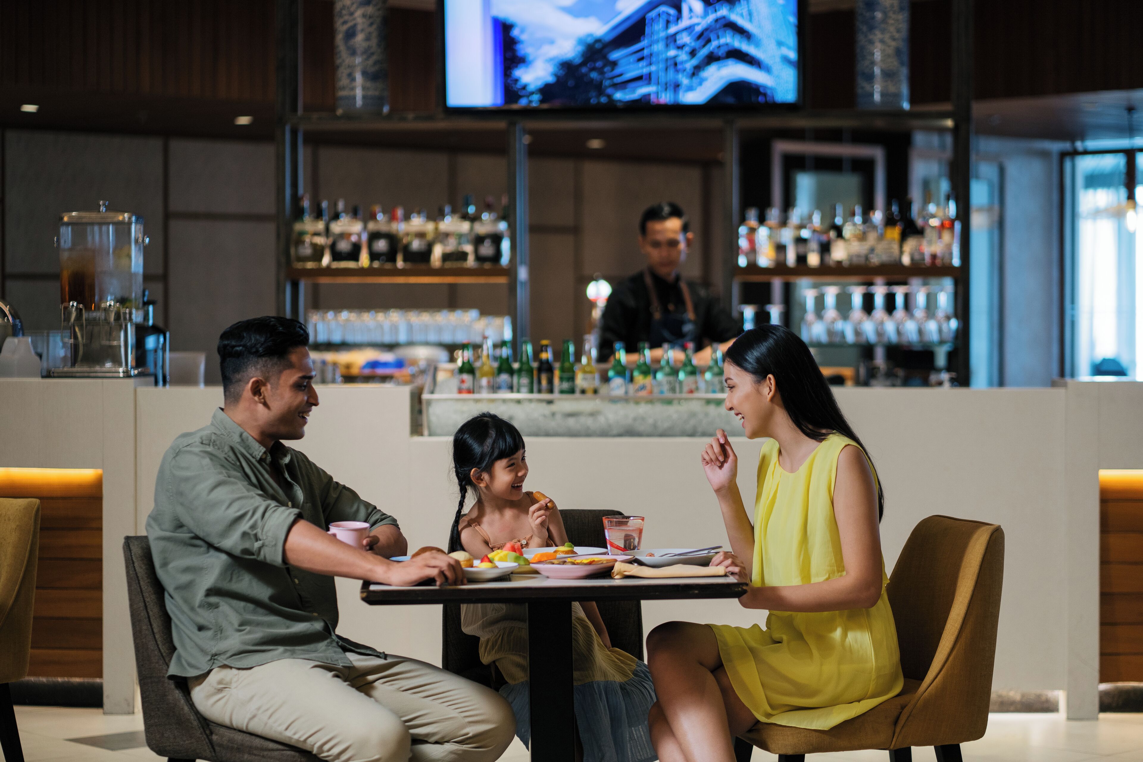 A bar area with a counter and shelves of bottles.