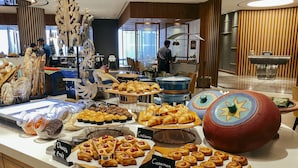 A bakery display with various pastries and a coffee station in a hotel lobby. - Four Points by Sheraton Surabaya, Pakuwon Indah (Surabaya)