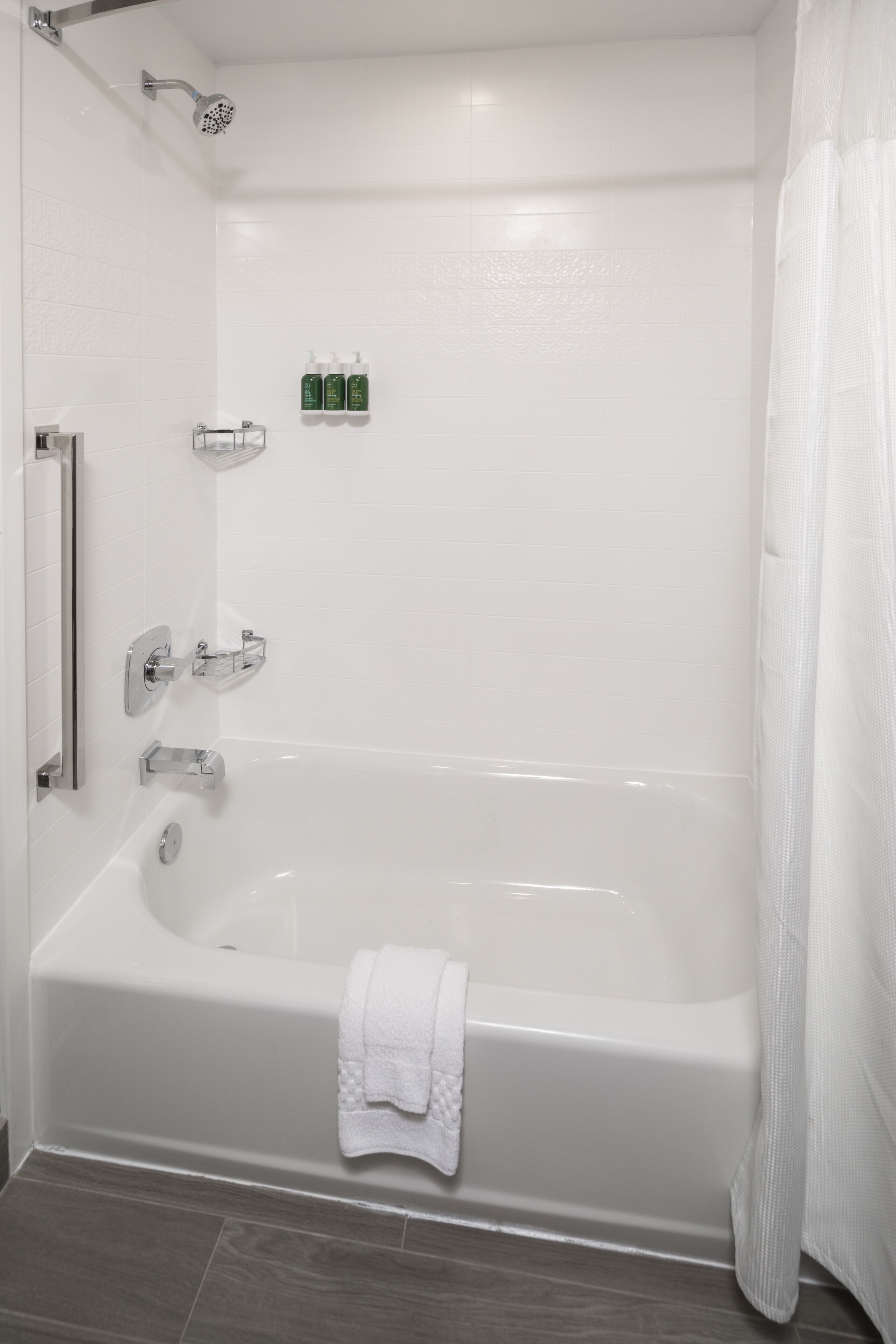 Ein modernes Badezimmer mit einer Badewanne, einer Duschbrause und einem Handtuchhalter.