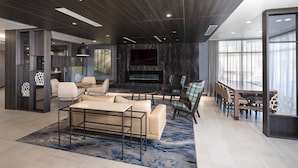 A modern living room with a large TV, comfortable seating, and a fireplace.