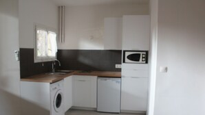 A compact kitchen with a washing machine, dishwasher, microwave, and a window providing natural light. - T2 fully equipped near all amenities bus, tram, train station, city center (Nice)