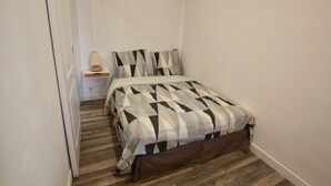 A small, neatly arranged bedroom with a bed, a nightstand, and a wall-mounted shelf. - T2 fully equipped near all amenities bus, tram, train station, city center (Nice)