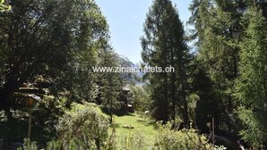 A forested area with a clear path, a birdhouse, and a stone structure in the background. - Individual chalet in Zinal - 1 bedroom with 1 bed - 1 bedroom with 3 beds - 2 bedrooms with 2 beds - (Zinal)