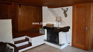 Un intérieur en bois agrémenté d’une cheminée, d’une lampe et d’une décoration représentant une tête de cerf.