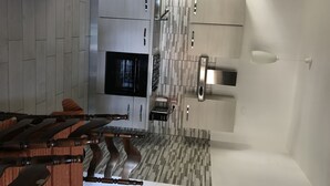 Uma cozinha moderna com forno embutido, eletrodomésticos de aço inoxidável e um painel de fundo padronizado.