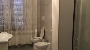 Casa de banho com sanita, bidé e lavatório.