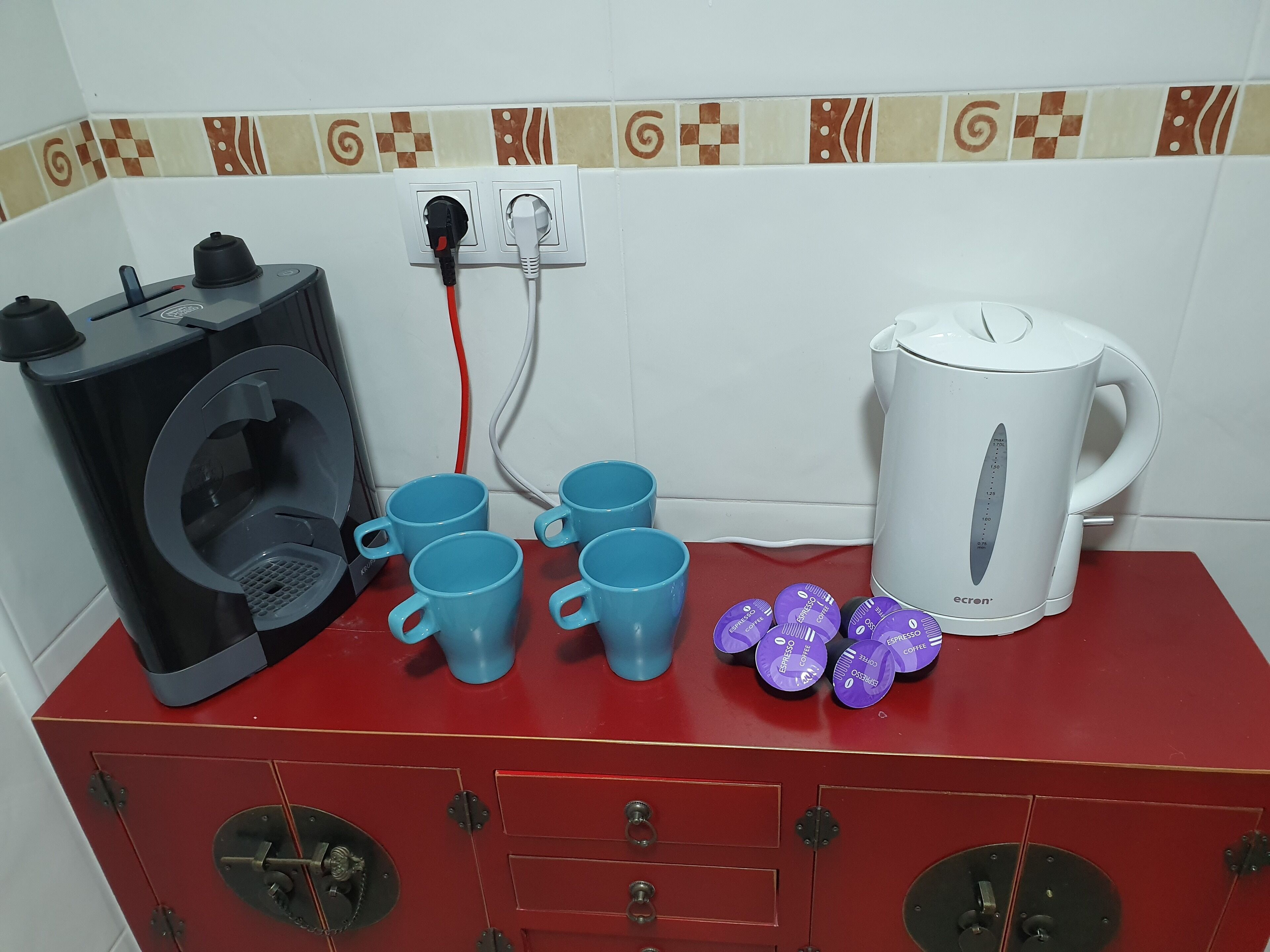 A kitchenette with a coffee machine, espresso pods, and a kettle.