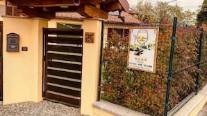 A building entrance with a metal gate, a small signboard, and a metal fence. - B&B Le Strade del Gavi (Francavilla Bisio)