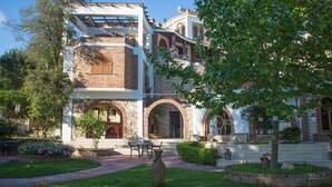 A traditional building with a stone facade, arched doorways, and a brick entrance. - Hotel Livia (Xarrë)