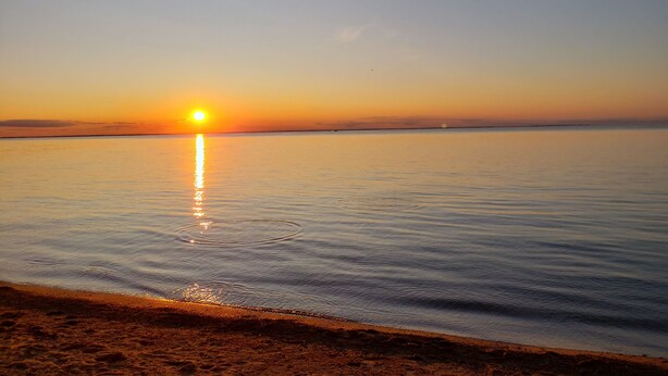 Mar tranquila al atardecer con cielo despejado.