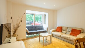Un salon moderne avec un canapé, une table basse et un téléviseur.