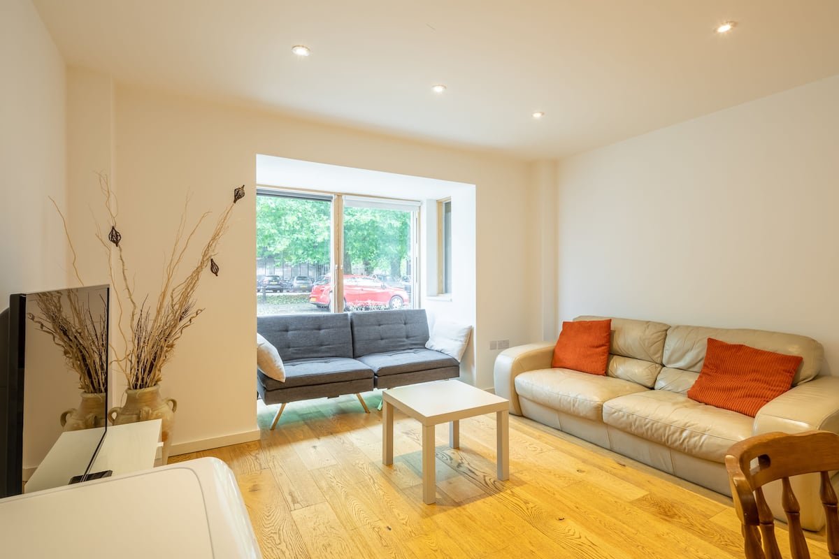 A modern living room with a sofa, a coffee table, and a TV.
