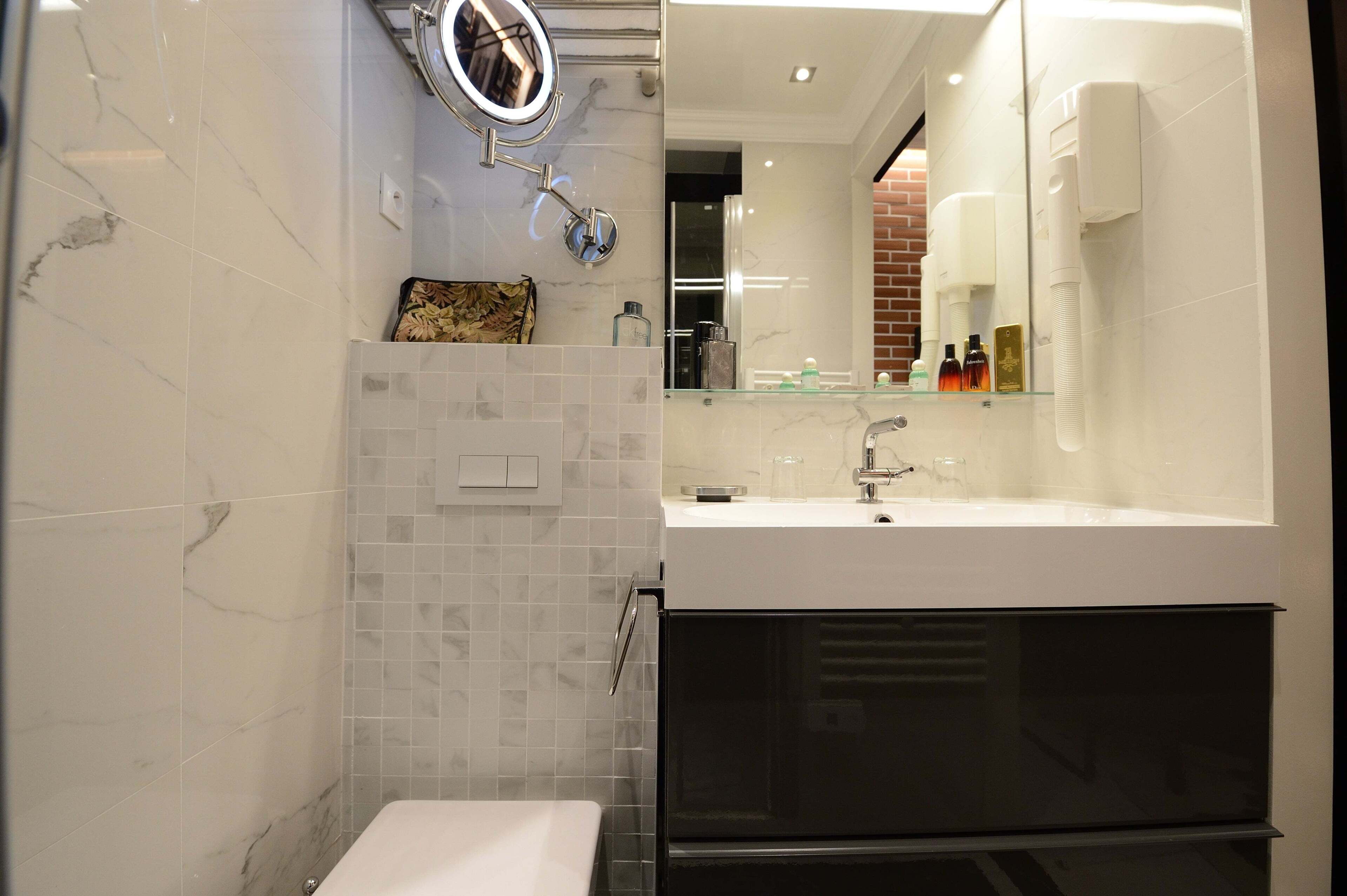 Un baño moderno con un espejo grande, un lavabo y una zona de ducha.