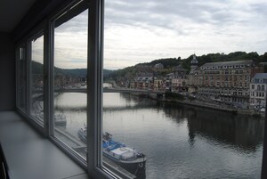 Vista de un río con barcos, un puente y edificios a lo largo de la orilla.