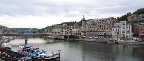 Blick auf einen Fluss mit einer Bootsanlegestelle, Gebäuden und einer Brücke.