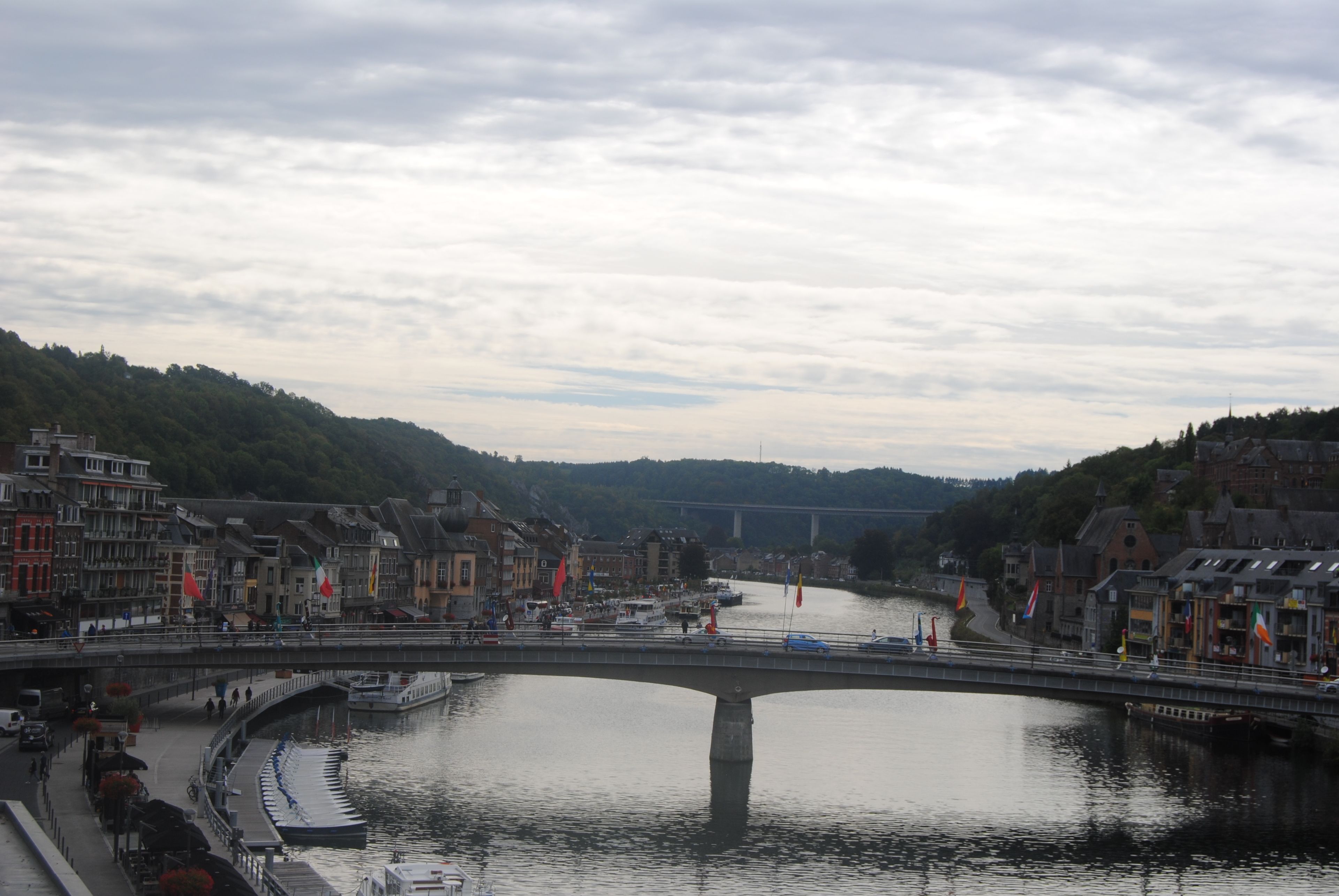 Un fiume con un ponte, imbarcazioni e edifici lungo le rive.