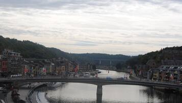 Un fiume con un ponte, imbarcazioni e edifici lungo le rive.