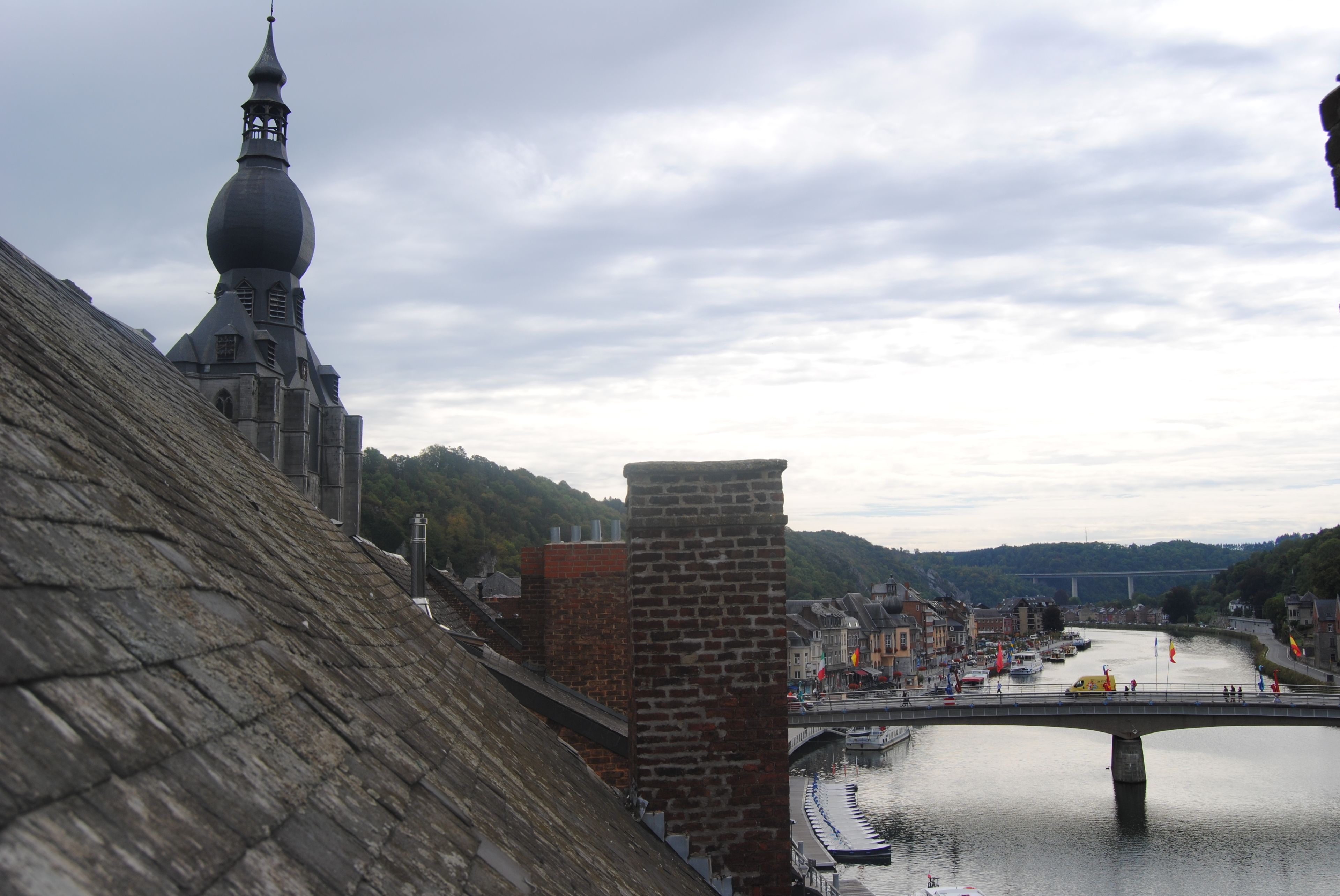 A historic building with a prominent tower and a bridge over a river.