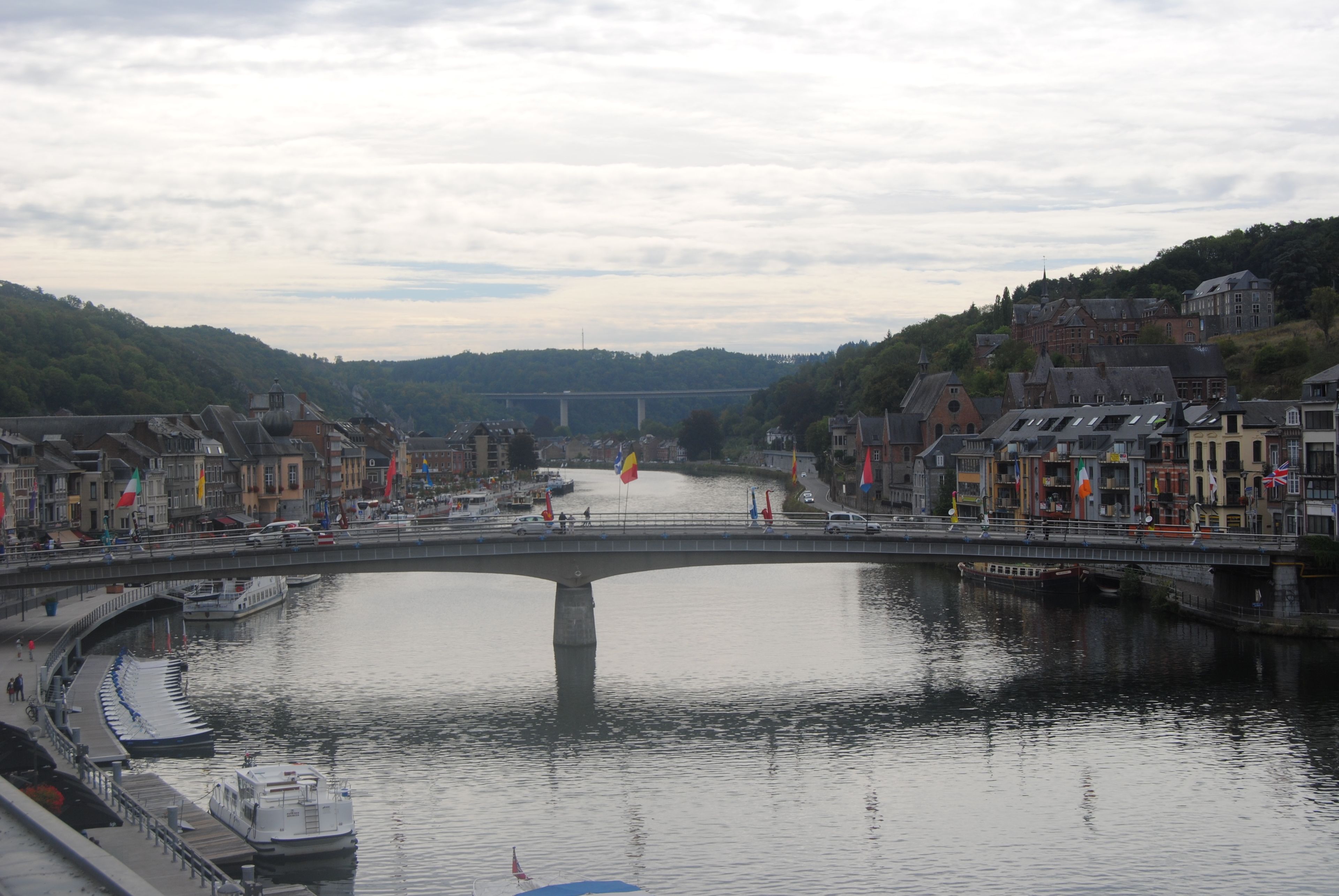 Ein Fluss mit einer Brücke, Gebäuden an beiden Ufern und Flaggen.