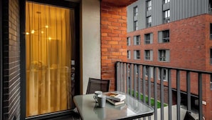 A balcony with a glass table, two chairs, and a book.