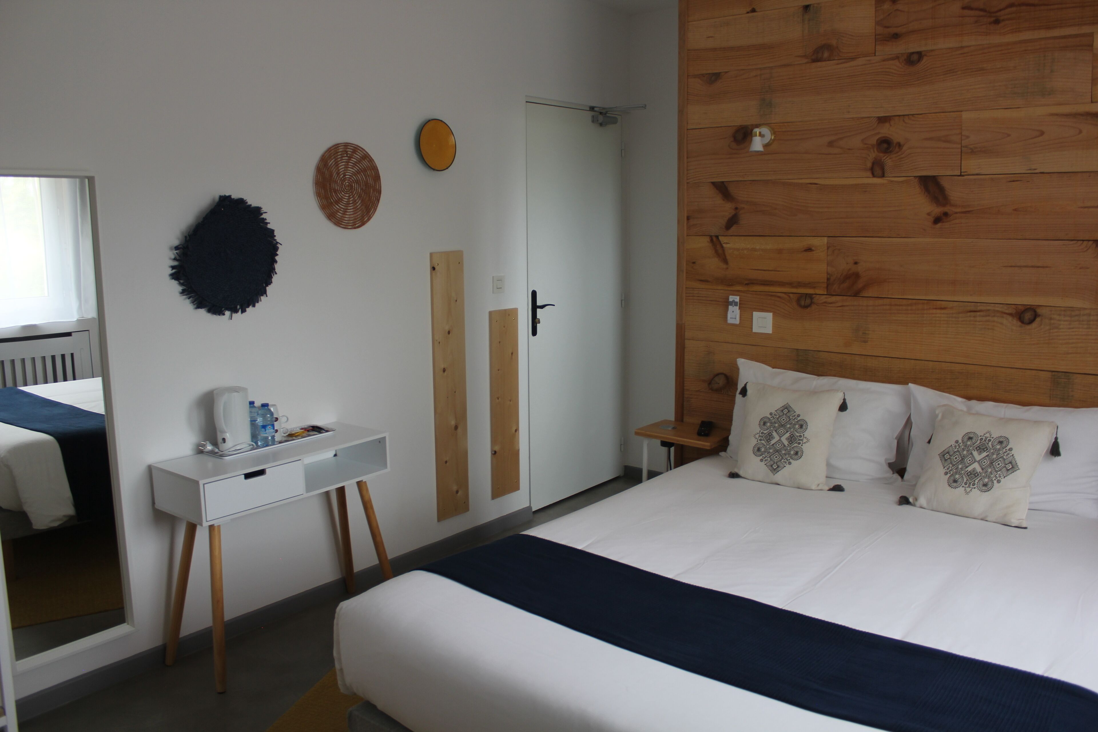 Une chambre à coucher avec un lit, une table de chevet et un miroir.
