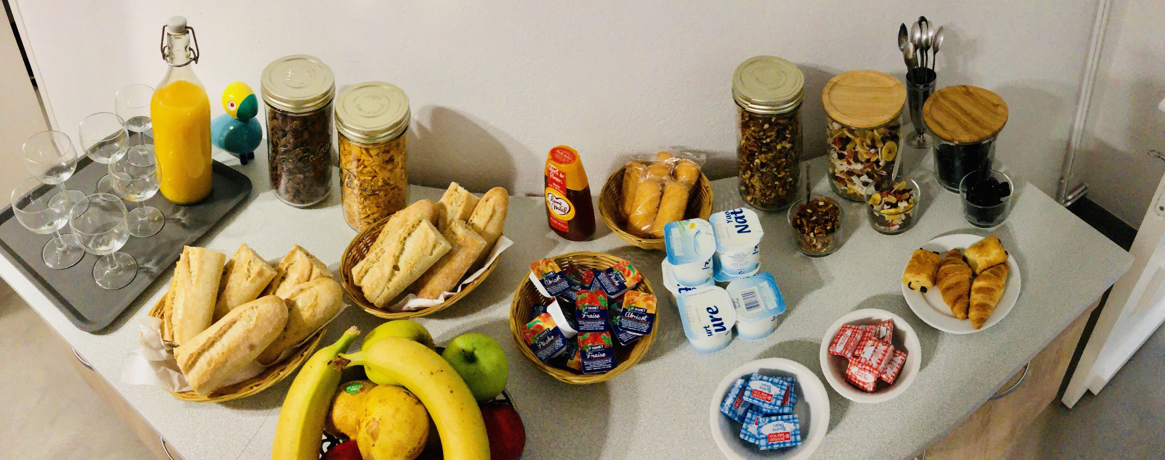 Ein Tisch mit verschiedenen Speisen, darunter Brot, Obst und Gewürzen.