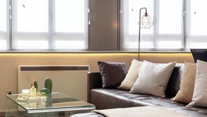 Una sala de estar moderna con una mesa de centro de cristal, un sofá de cuero y una lámpara decorativa.