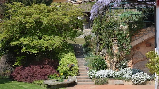 Un jardín con una escalera de piedra que lleva a una casa de techo rojo.
