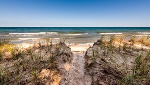 A beach with a clear path leading to the water, surrounded by sand dunes and grass. - HARBERT PRIVATE LAKEFRONT HOME WITH PRIVATE HOT TUB! (Harbert)