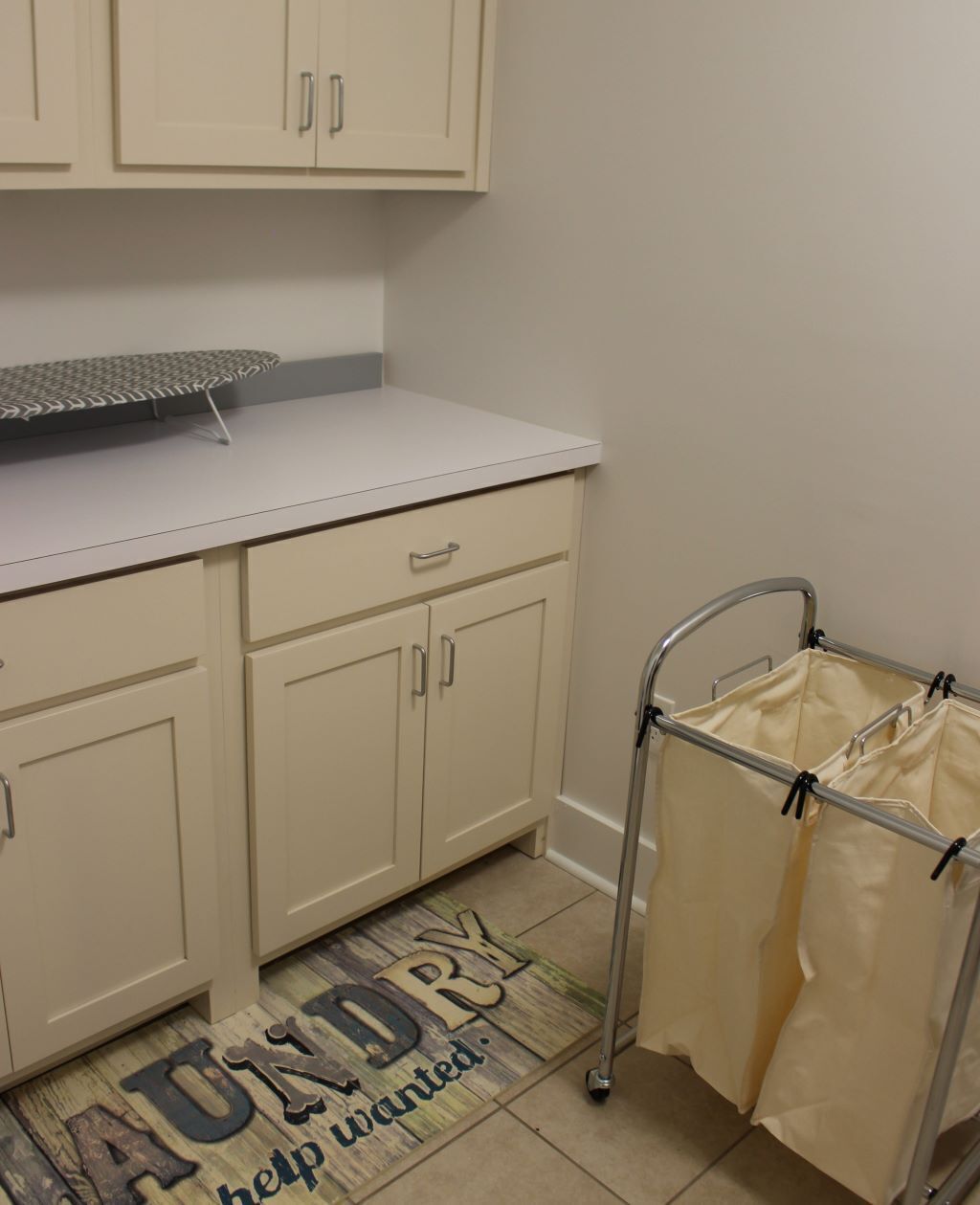 A kitchenette with cabinets, a countertop, and a metal drying rack.