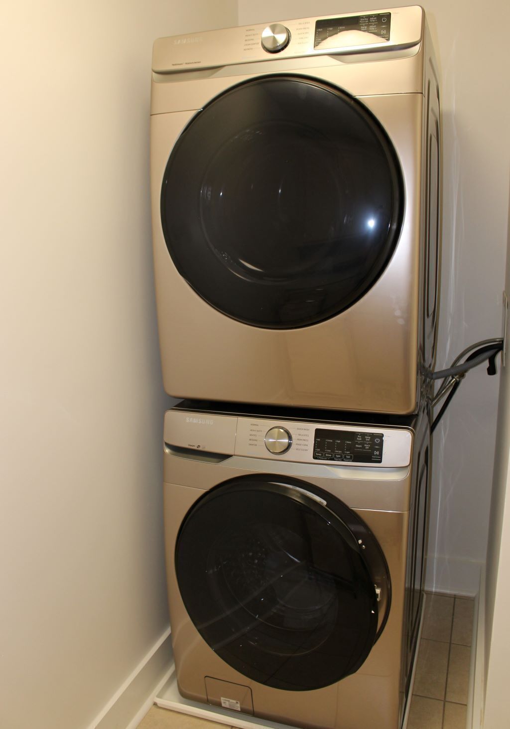 A stacked washer and dryer unit in a laundry room.