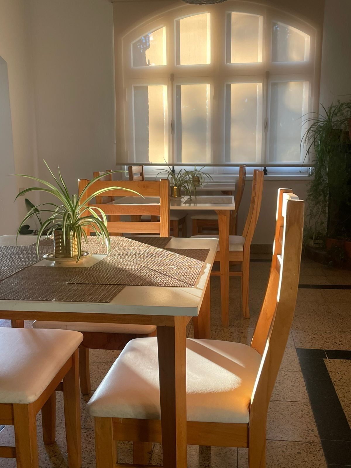 Una zona de menjador amb una taula, cadires i una finestra amb llum solar.