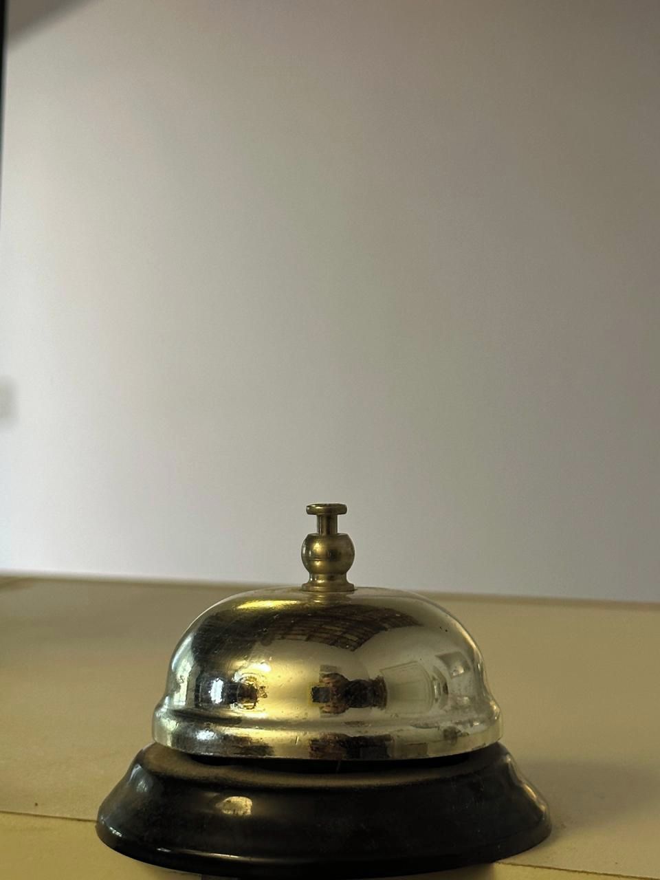 A metallic bell with a dome top and a base, likely used for signaling room service or guest requests.