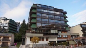 Un edificio de varias plantas con un diseño arquitectónico moderno, que combina elementos de vidrio y metal, y un techo plano.