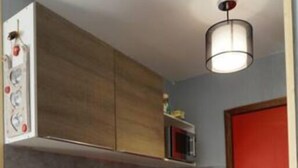 Una cocina compacta con armarios de madera, microondas, fregadero y lavavajillas.