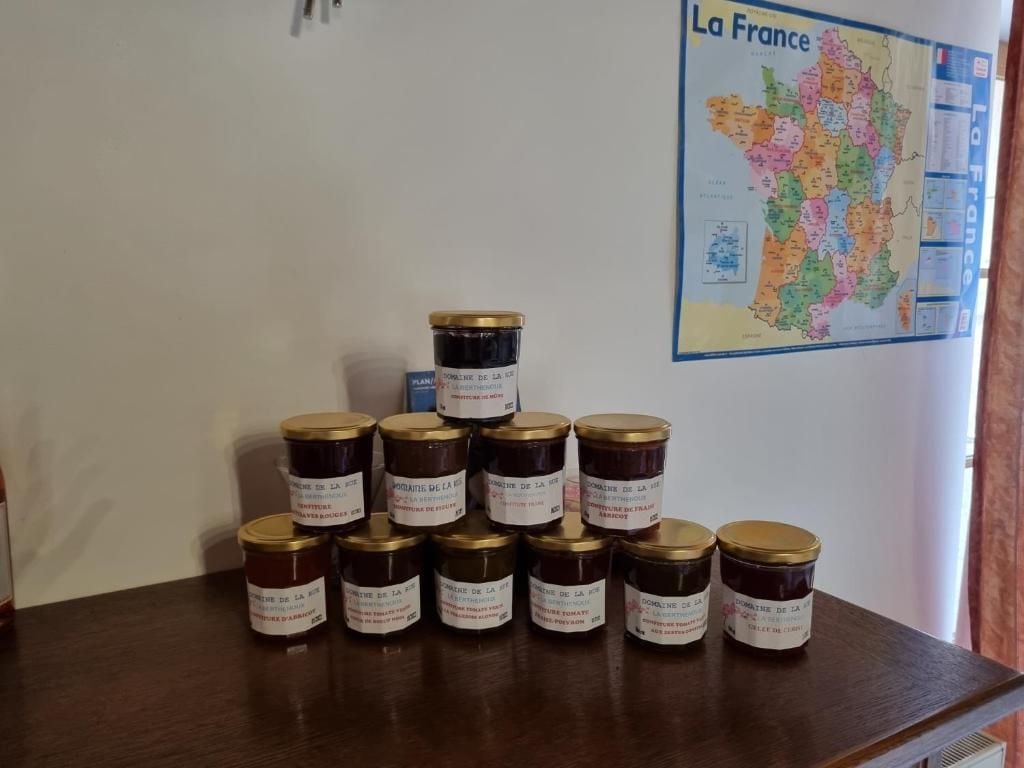 Une table avec des pots de confitures, une carte de France et une fenêtre avec des rideaux.