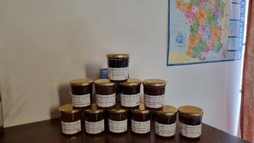 Une table avec des pots de confitures, une carte de France et une fenêtre avec des rideaux.