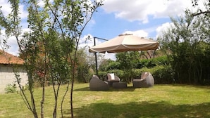A patio area with outdoor furniture, a pergola, and a small tree. - Domaine de la Rue (La Berthenoux)