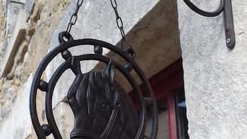 A metal sign with a horse's head and the word "BIENVENUE" hanging from a building.