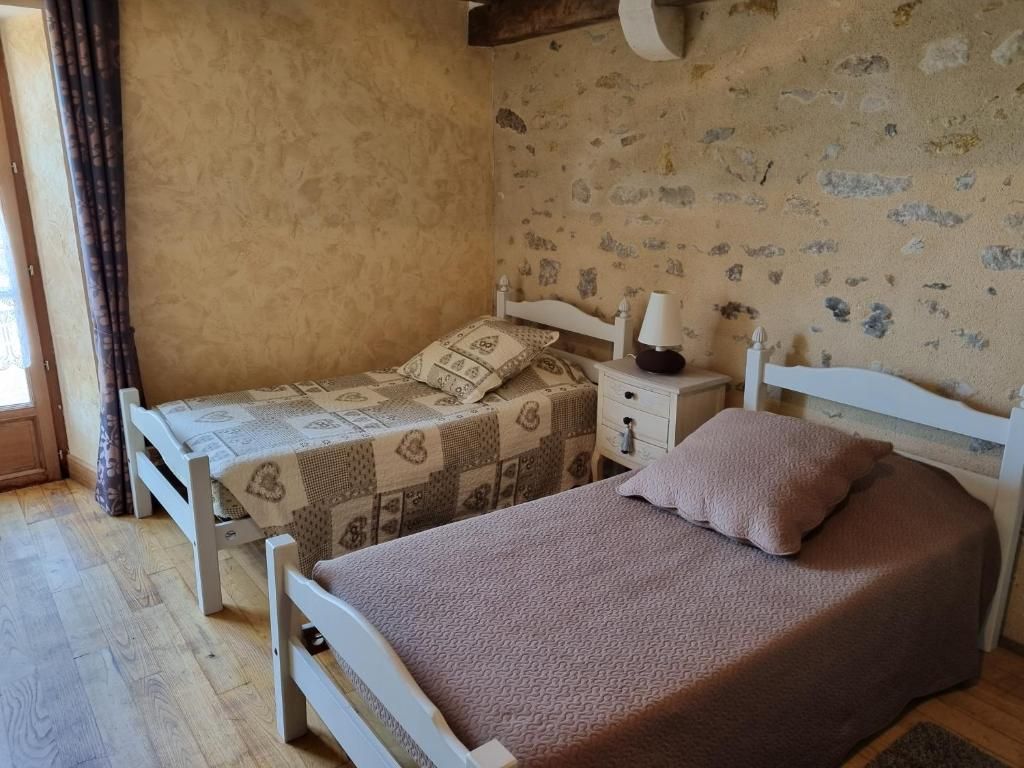A bedroom with two beds, a nightstand, and a wall with animal prints.