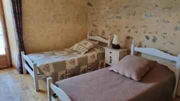 A bedroom with two beds, a nightstand, and a wall with animal prints.