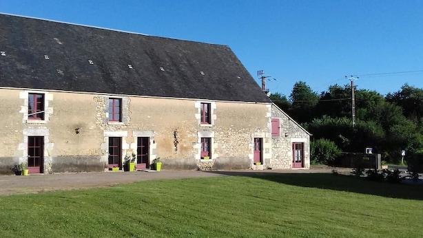 A stone building with multiple windows and a sloped roof. - Domaine de la Rue (La Berthenoux)